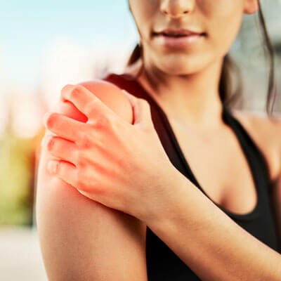 woman holding her shoulder in pain